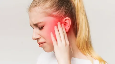 Mulher com dor na região do nervo trigêmeo — causas da nevralgia